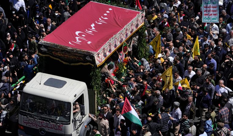 Iranian mourners gather around a truck carrying the coffins of Revolutionary Guard members killed in an airstrike